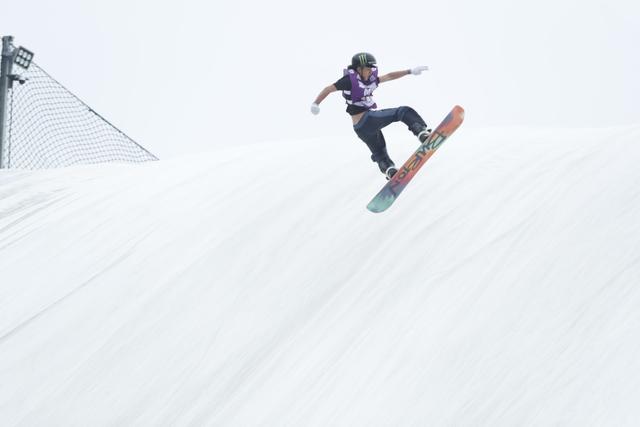 滑雪運(yùn)動(dòng)員穿著短袖在旱雪上進(jìn)行比賽